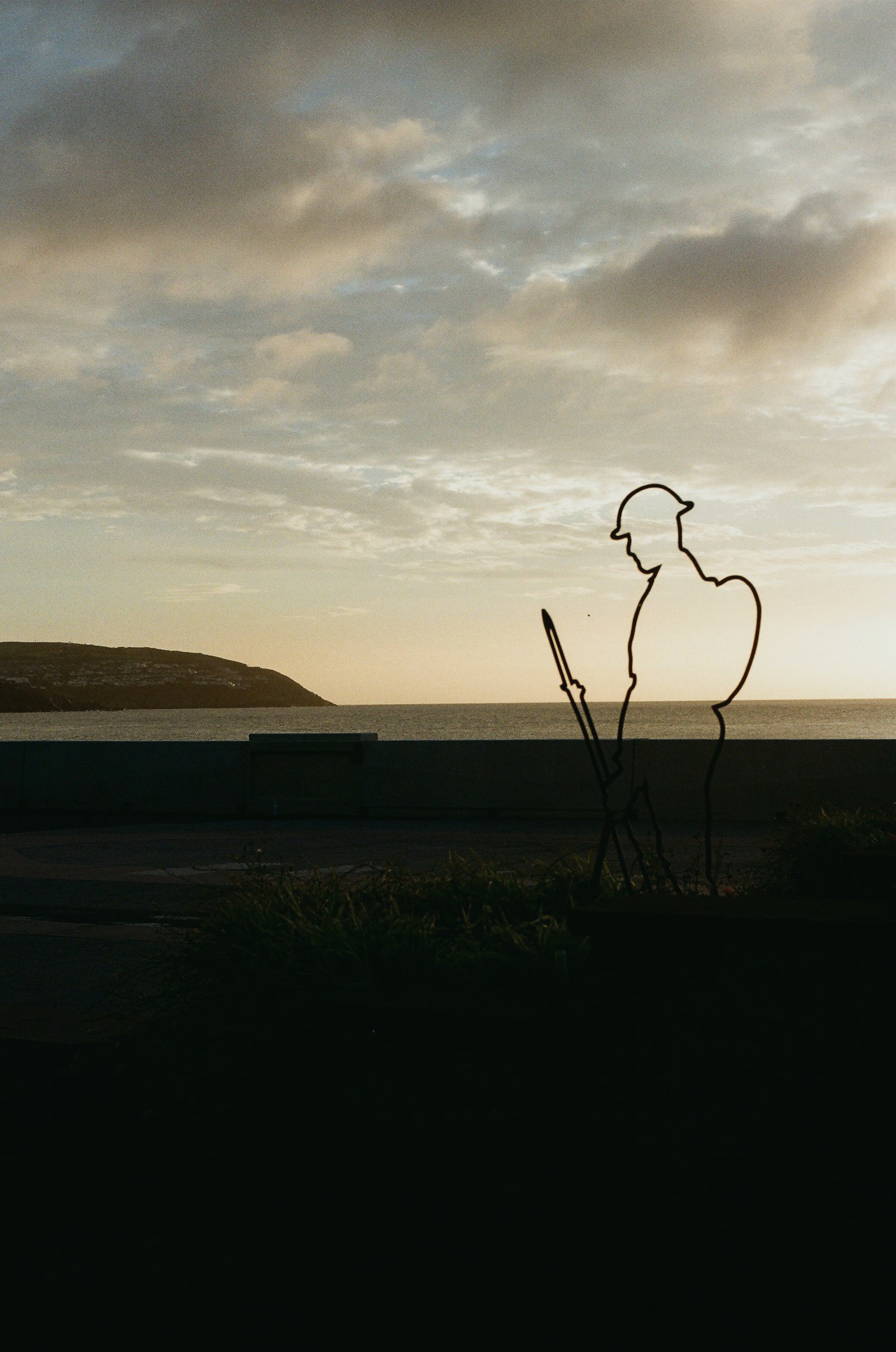 Silhouette of a soldier memorial at dusk by the sea